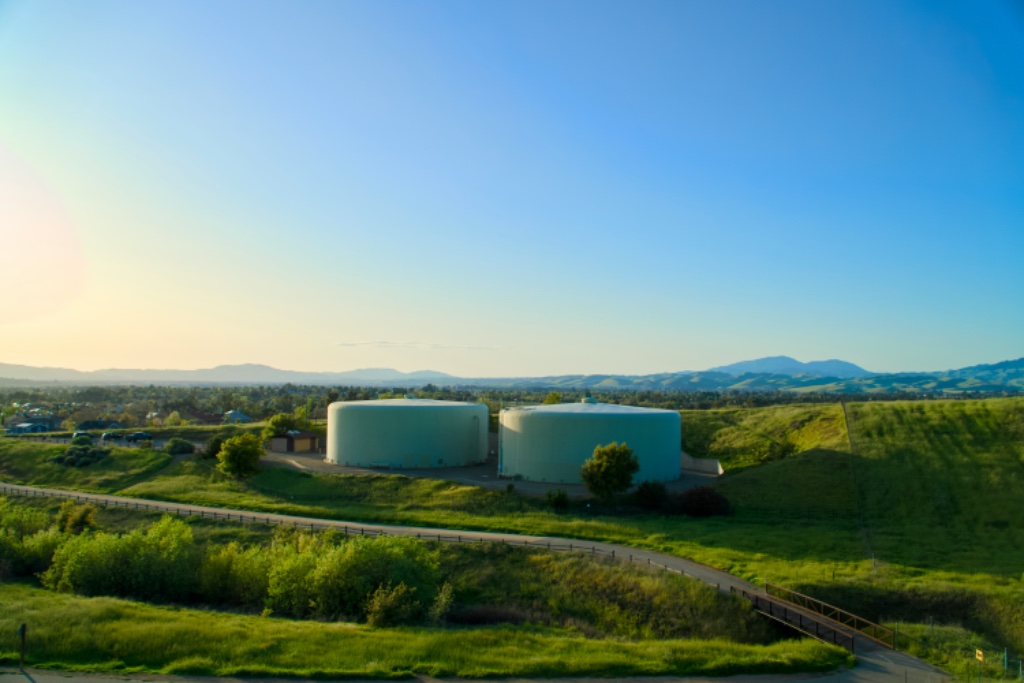 Biogas plant with large cylindrical tanks in a green landscape